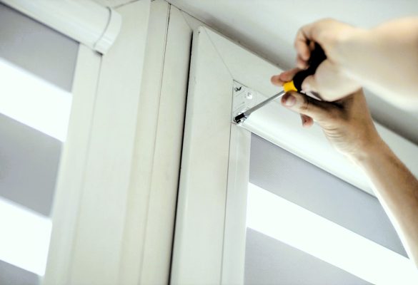 Man installing cassette roller blinds on windows